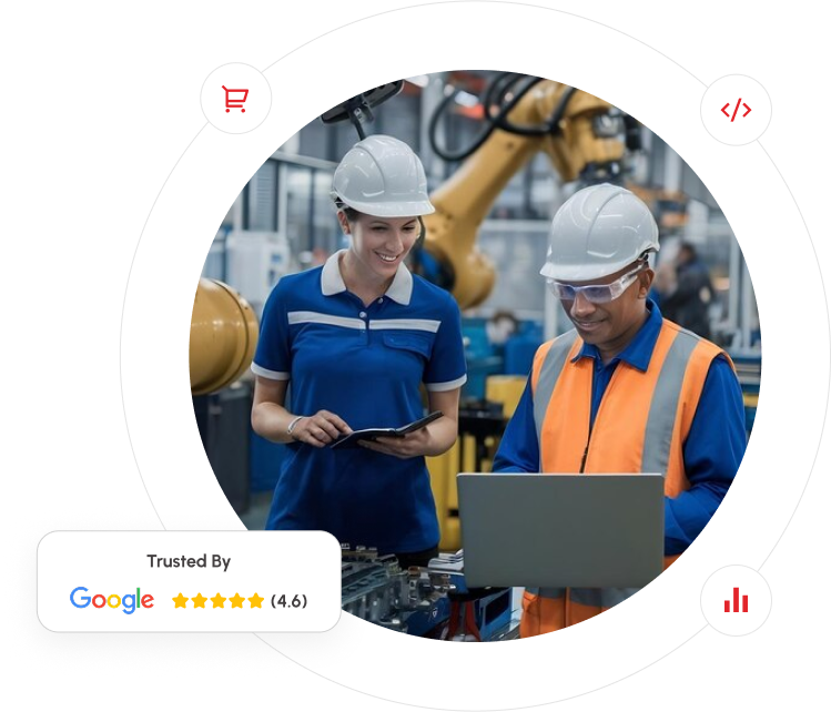 Two people collaborating on a laptop in a manufacturing facility, surrounded by industrial equipment and machinery.