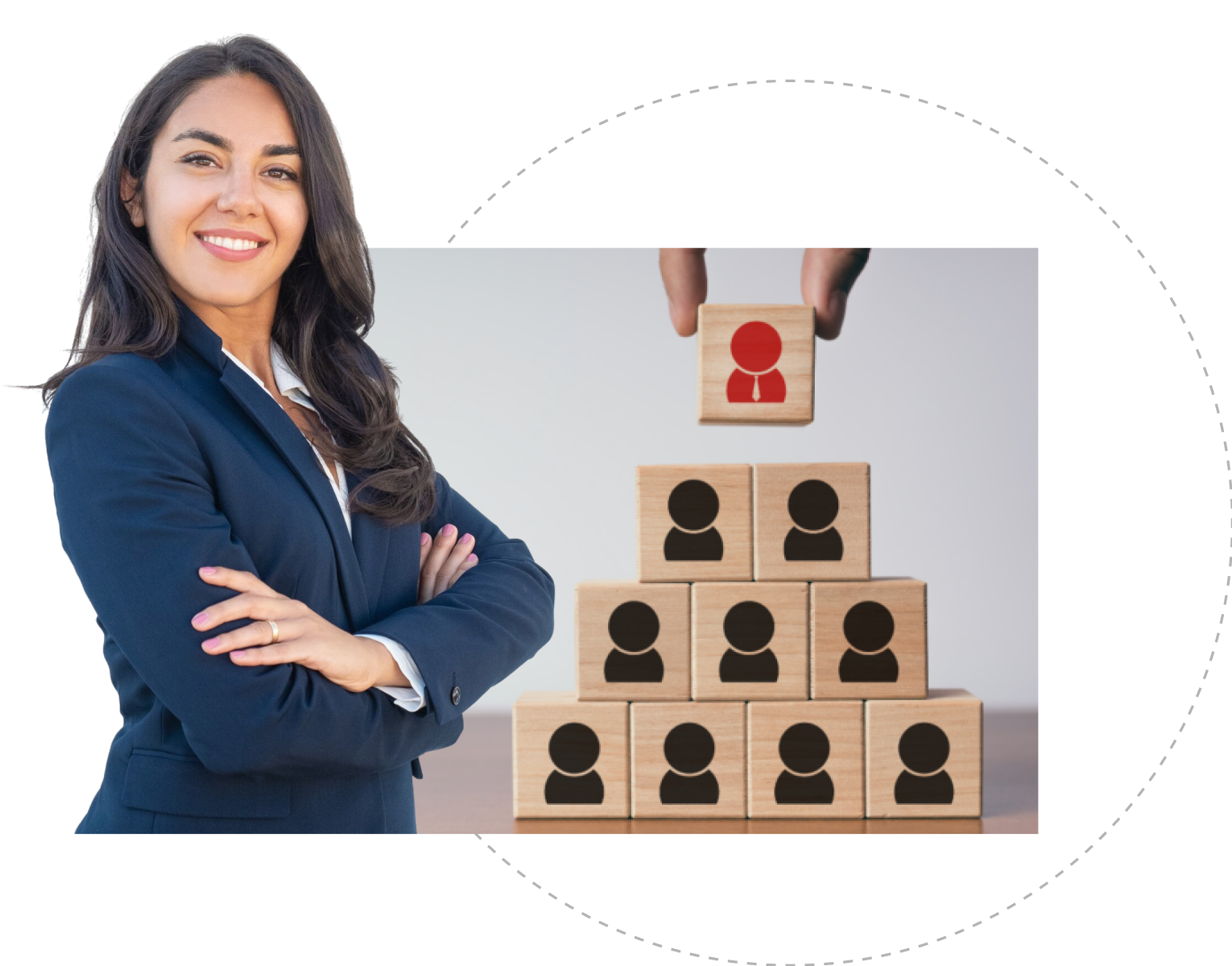 A woman with a smile stands beside a tall stack of wooden blocks. She is wearing casual clothing.
